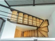 Un escalier en métal et bois qui laisse passer la lumière