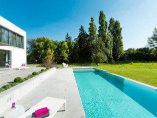 Une piscine se déverse sur un jardin verdoyant