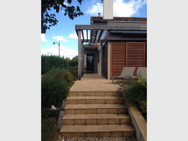 Une pergola en bois naturel qui habille la terrasse - Deux extensions en bois pour une maison plus fonctionnelle