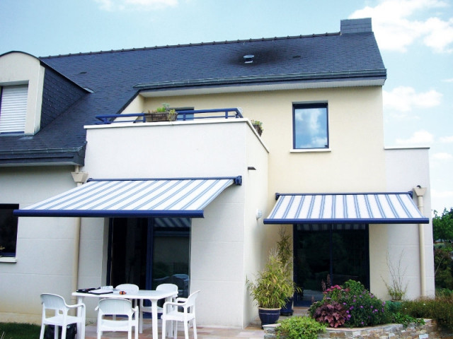 Des stores aux coffres bleus comme le garde-corps du balcon - Un store de terrasse en harmonie avec la maison