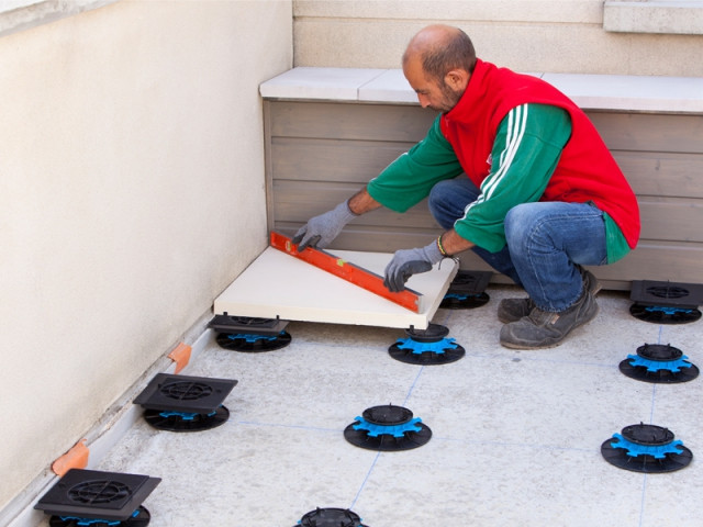 Pose des dalles rangée par rangée - Rénovation terrasse sur plots