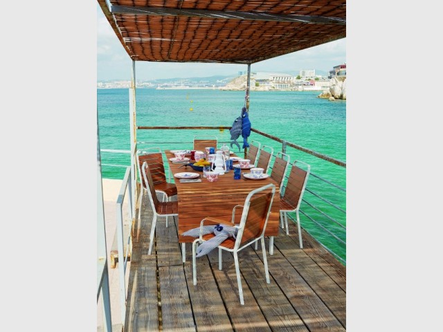 Une table en bois pour un repas comme sur un bateau à l'extérieur  - Tables estivales