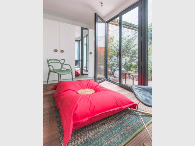 Un préau aménagé comme prolongement de la terrasse  - Appartement parisien atypique avec jardin