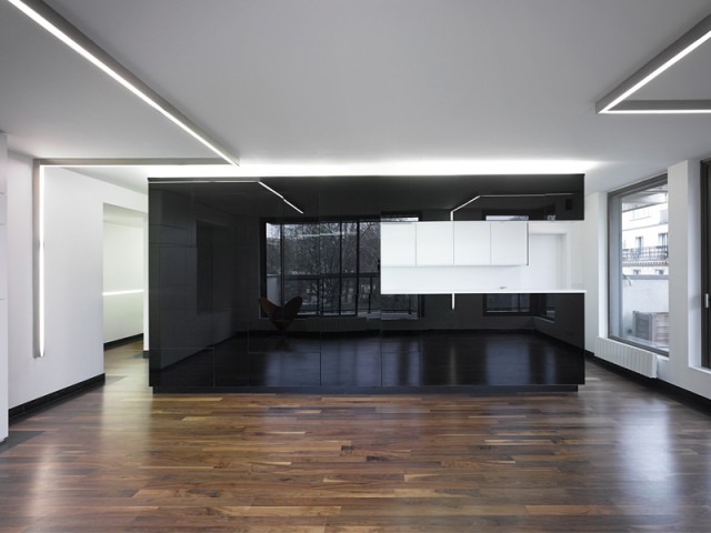 Un bloc monolithe noir laqué pour structurer l'appartement - Un intérieur minimaliste noir et blanc