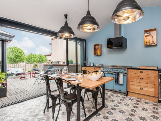 Bois brut et style industriel pour une cuisine ouverte sur une terrasse