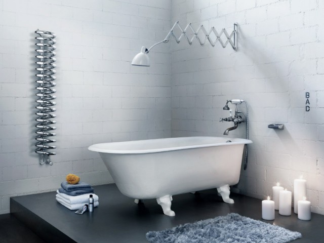 Un radiateur sèche-serviettes en métal dans une salle de bains industrielle - Sèche-serviette