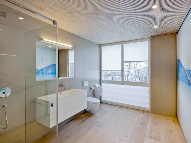 Une salle de bains aux murs couverts de Hi-Macs - Un chalet ouvert sur la montagne