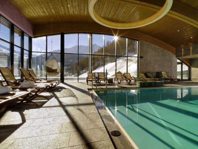 Une piscine surplombée d'un luminaire design - Bergland Hotel Sölden