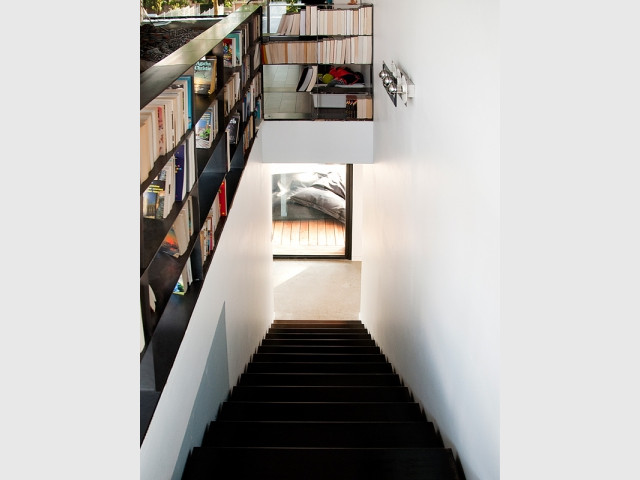 Un escalier/bibliothèque en acier brut - Une maison construite entre les arbres