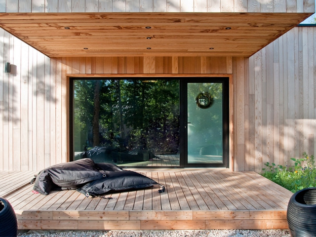 Un porte à faux utilisé comme protection solaire - Une maison construite entre les arbres