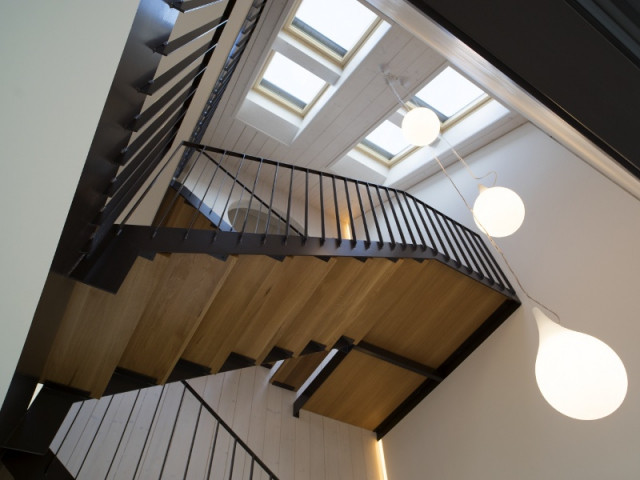 Un escalier moderne et élégant inondé de lumière  - Une maison comme un mille-feuille de bois