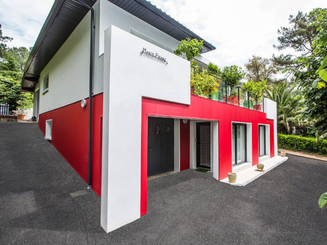 Une maison pour deux appartements distincts - un rouge flamboyant pour la façade d'une maison