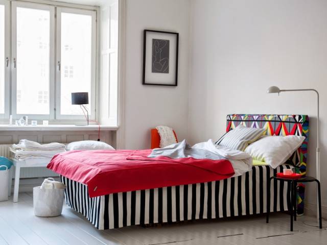 Une tête de lit recouverte d'une housse en tissu coloré et graphique