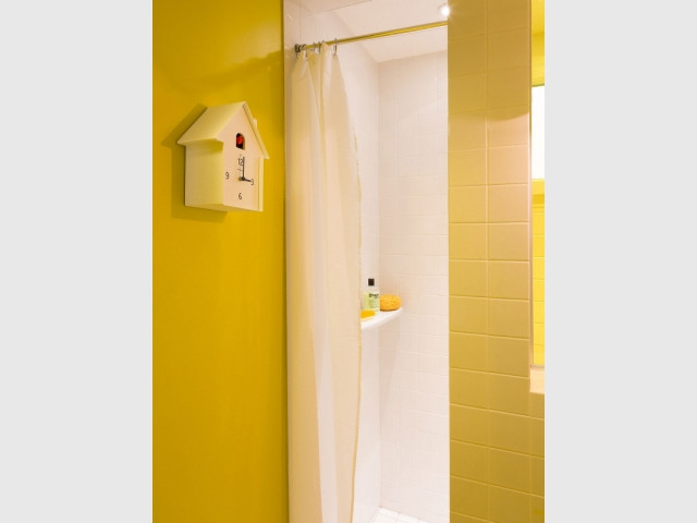 Une salle de bains jaune et blanche ultra dynamique