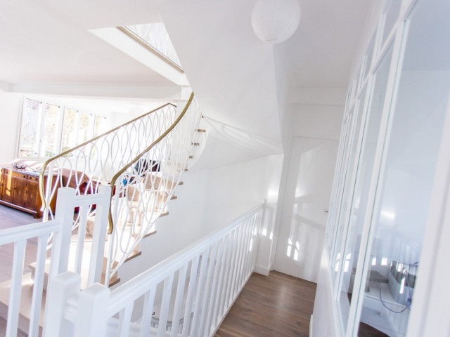 Près de l'escalier et du bureau, la porte de la chambre