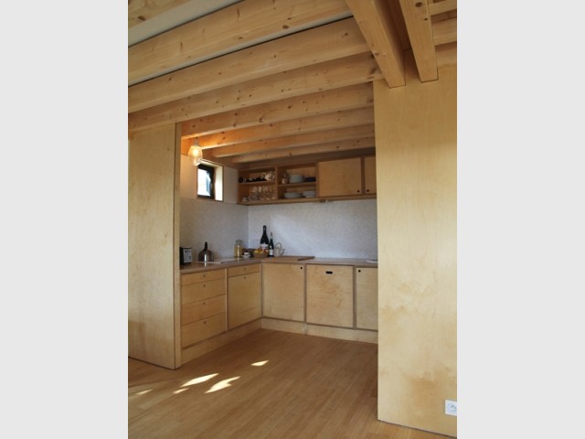 Une cuisine tout en bois ouverte sur la pièce à vivre