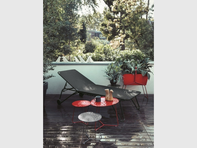 Un balcon urbain aux teintes rouge vif et gris