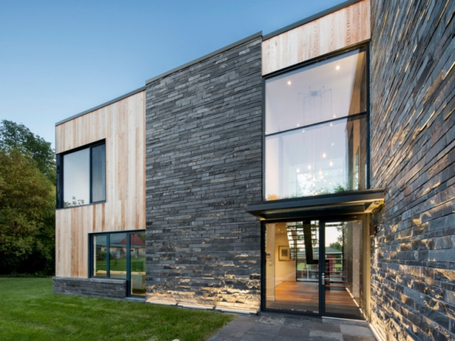 Une maison enveloppée de fausses ardoises et de bois