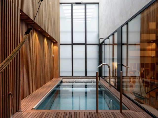 Une piscine intérieure enveloppée de bois