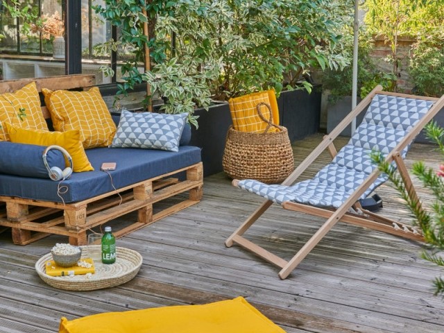 Un canapé en palettes sur une terrasse en jaune et anthracite