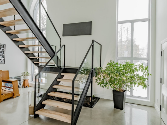 Un escalier en verre, bois et métal