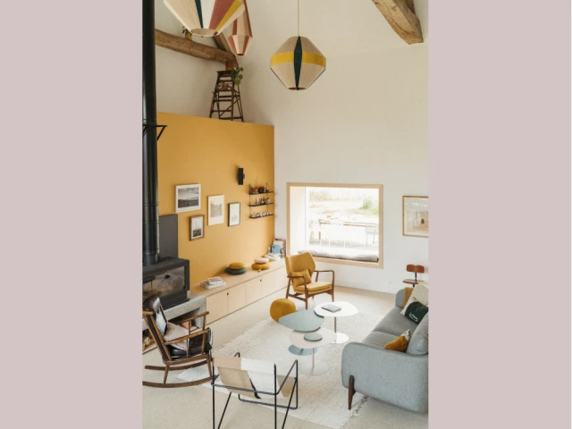 Dans le salon, un mur ocre apporte de la chaleur à la pièce