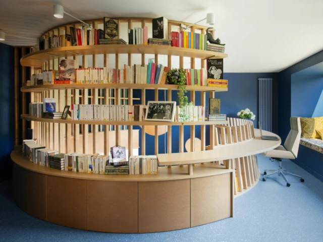 Une bibliothèque monumentale avec coin lecture et bureau