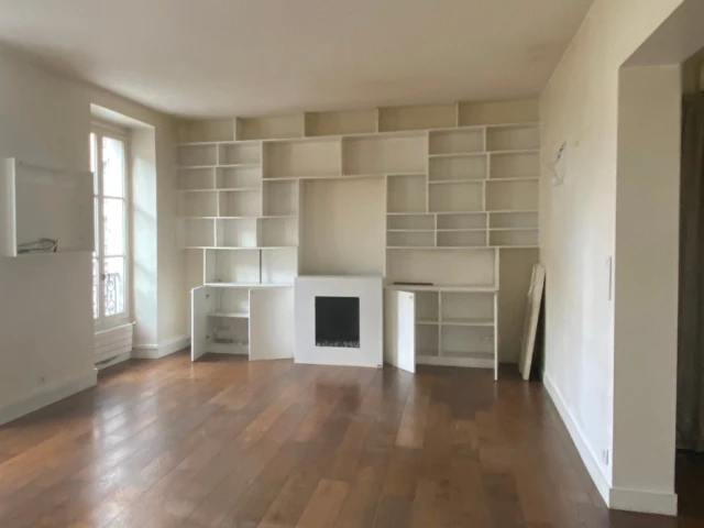Avant : un séjour avec bibliothèque et cheminée au gaz
