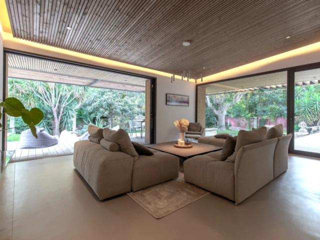 Un grand salon baign&eacute; de lumi&egrave;re avec un sol en b&eacute;ton cir&eacute;