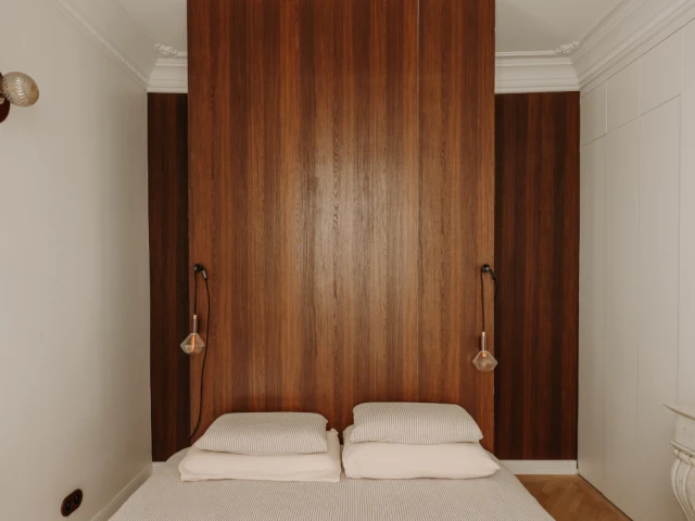 La t&ecirc;te de lit dissimule deux ouvertures qui desservent une salle d'eau et un dressing.