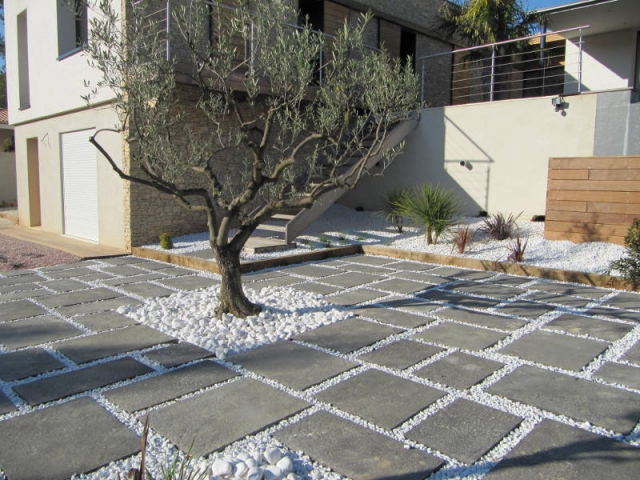 Une terrasse en dalles de pierre reconstitué et gravier