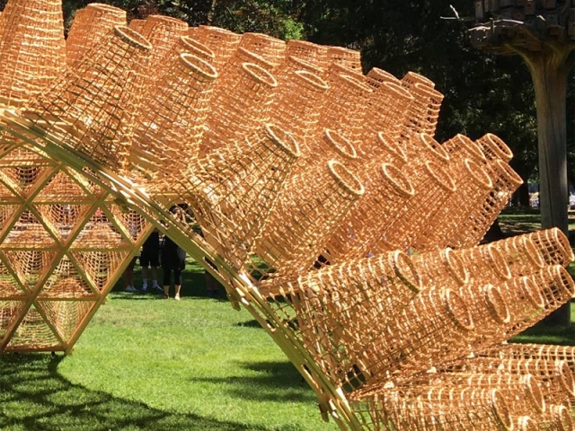 Une structure en bois, en forme de canopée, surmontée de 260 paniers en osiers