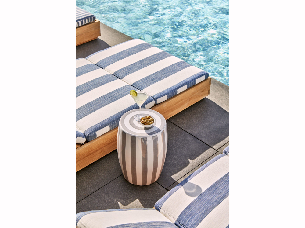 L'ambiance estivale est compl&eacute;t&eacute;e par du mobilier d&eacute;di&eacute; au bord de la piscine 