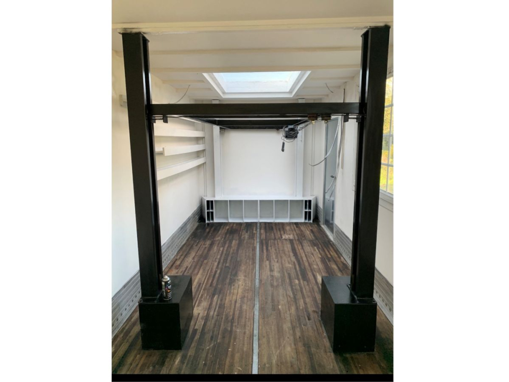 Interieur maison Tournesol avec pont élévateur de voiture qui permet au lit de monter et de descendre