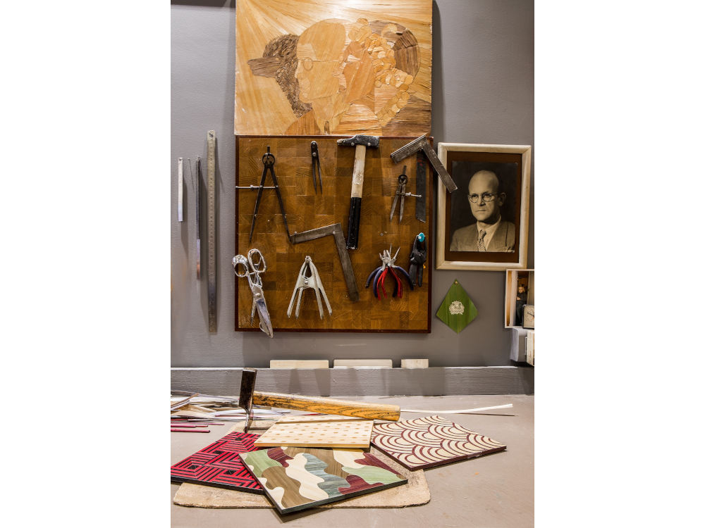 L'autoportrait de famille, r&eacute;alis&eacute; par Andr&eacute; Groult en marqueterie de paille, accroch&eacute; au-dessus de l'&eacute;tabli, veille sur Lison de Caunes.