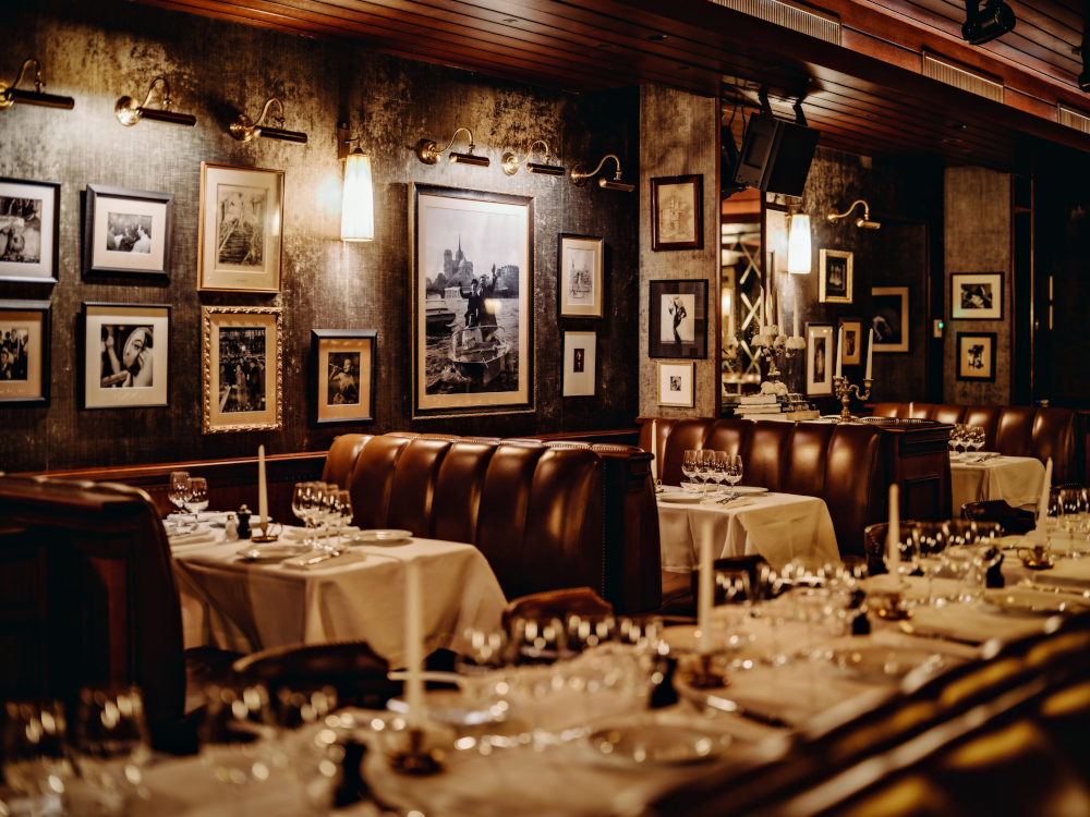 Le restaurant Le Pompon, à Paris : boiseries, cadres chinés et lumières tamisées, dans l'esprit d'un lieu qui aurait toujours existé.